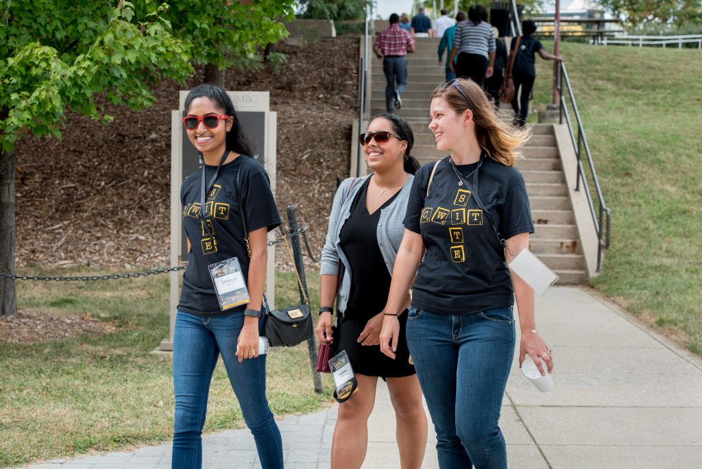 Three CWIT students walking on campus in CWIT shirts