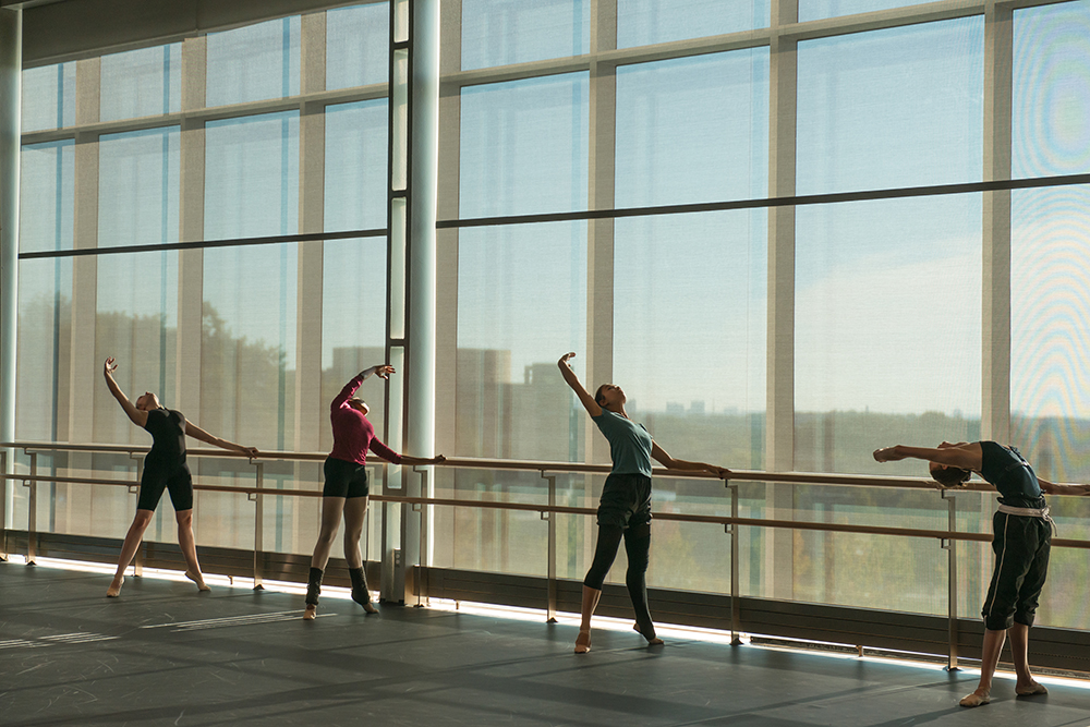 Four students at the barre in the UMBC dance cube