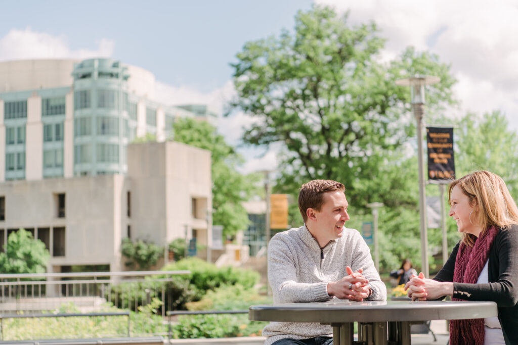Randy and his mentor, professor Jamie Gurganus, talk about his project at a table outside the UMBC library.