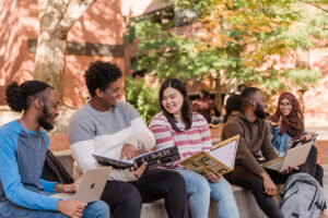 A diverse group of students, studying outside together.