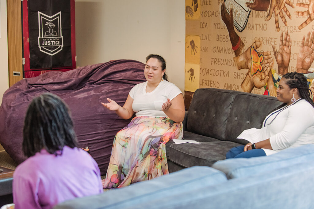 three women of diverse backgrounds, in conversation together